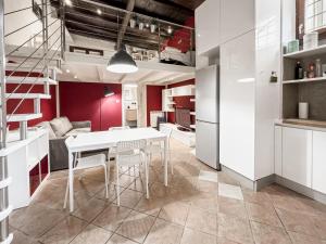 cocina y comedor con mesa blanca y sillas en Realkasa Bolognetti Apartment, en Bolonia