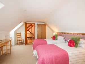 a bedroom with two beds and a table and a desk at Rhyd Y Bont Bach in Holyhead
