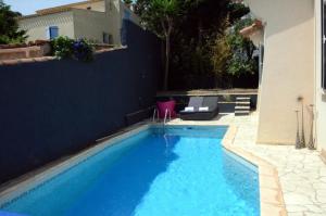 a large blue swimming pool next to a building at Les Jardins De Galicia in Sète