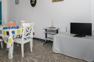 Zimmer mit einem Tisch, einem TV und Stühlen in der Unterkunft Europa B 6º-23 in Cullera