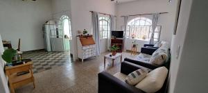 a living room with two couches and a kitchen at Sueño Cumbre. Casa Lavanda in La Cumbre