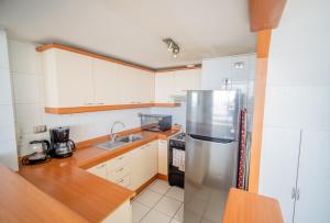 a kitchen with a stainless steel refrigerator and a sink at Hermoso loft en Iquique in Iquique