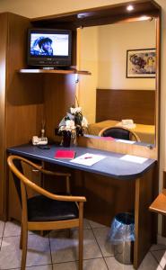 uma secretária num quarto de hotel com uma televisão por cima em ALLOGGI VITALE em Cesano Maderno