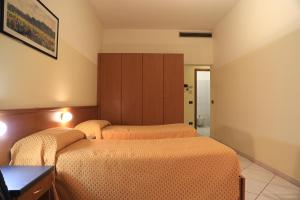 um quarto com 2 camas e um armário em ALLOGGI VITALE em Cesano Maderno