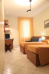 um quarto de hotel com duas camas e uma televisão em ALLOGGI VITALE em Cesano Maderno