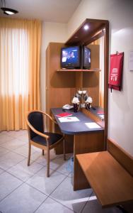 um quarto com uma secretária com uma cadeira e uma televisão em ALLOGGI VITALE em Cesano Maderno