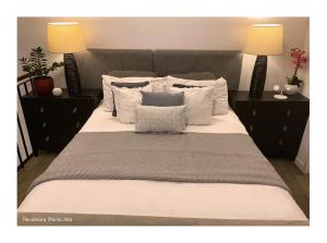 a large bed with two lamps and two pillows at Charming and Relaxing Home in Guatemala