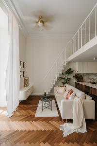 een woonkamer met een witte bank en een trap bij Przy Przystani Apartament Paryski in Wrocław