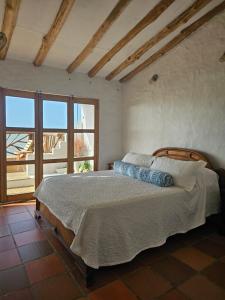 ein Schlafzimmer mit einem Bett und einem großen Fenster in der Unterkunft El Secreto in Dibulla