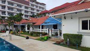 a house with a swimming pool next to a building at Resort 2-3BR Huge Pool, BBQ, 300m-Beach, 5 mins to Walking Street in Pattaya South