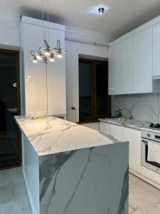 a kitchen with white cabinets and a marble counter top at Family Guest House in Yerevan