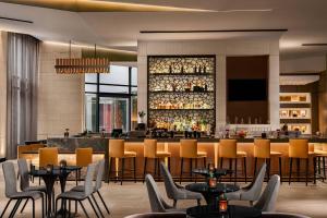 um restaurante com mesas e cadeiras e um bar em AC Hotel by Marriott Phoenix Downtown em Phoenix