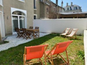 a group of chairs and a table in a yard at La Villa Maignan - Centre ville - Jardin - 15p in Le Mans