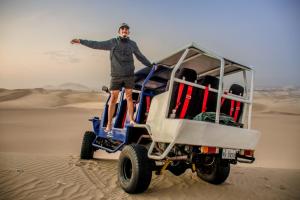 Un uomo in piedi su un veicolo nel deserto di HAWKA a Ica