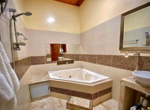 ein Badezimmer mit einer Badewanne und einem Waschbecken in der Unterkunft Martina House in Iquitos