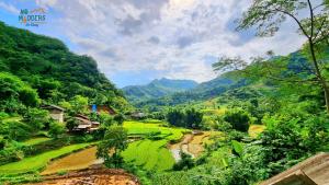a view of a lush green valley with mountains at NoMadders Ha Giang in Ha Giang