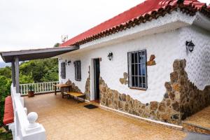 Casa blanca con techo rojo y patio en Eco House in Unique Environment, en La Orotava
