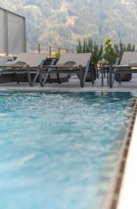 una piscina con tumbonas junto a una piscina en Fankhauser Apartments, en Ried im Zillertal