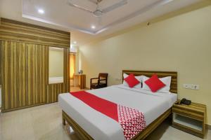 - une chambre avec un grand lit et des oreillers rouges dans l'établissement OYO Flagship 13636 Hotel Srinika Grand NEAR Shamshabad Airport, à Shamshabad