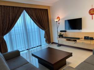 sala de estar con sofá y ventana grande en The Floorspace Imperial Suites Apartment, en Kuching