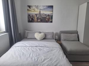 Schlafzimmer mit einem Bett mit einem Herzkissen in der Unterkunft Studio Apartment 8 in Essen