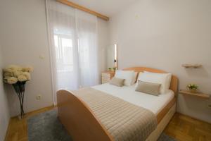 a bedroom with a bed and a vase of flowers at City Nest apartment in Podgorica