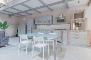 a kitchen with a blue table and white chairs at Appartamento a Piacenza in Piacenza