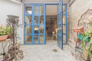 a blue door leading to a patio with plants at Appartamento a Piacenza in Piacenza