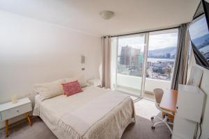 1 dormitorio con cama y ventana grande en Hermoso departamento en la Peninsula, en Iquique