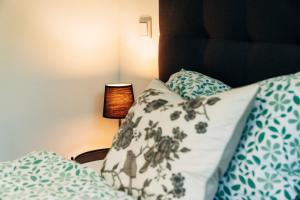 un letto con cuscini blu e bianchi e una lampada di X Kowloon a Westerholz Altre 29 foto