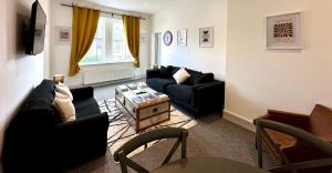 a living room with two couches and a table at Stylish 3Bed apartment with FREE PARKING in Heaton