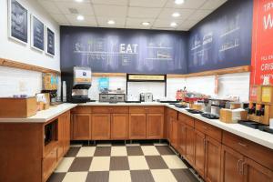 una gran cocina con armarios de madera y una pared azul en Hampton Inn Bordentown en Bordentown