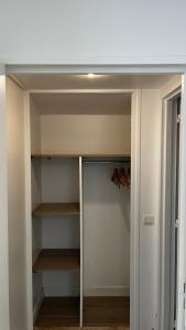 a walk in closet with wooden shelves and a ceiling at Hôtel Marie Louise in Enghien-les-Bains