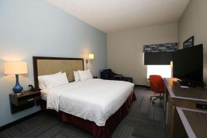 a hotel room with a bed and a flat screen tv at Hampton Inn Bordentown in Bordentown