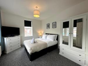 a bedroom with a bed and a flat screen tv at Stylish 3Bed apartment with FREE PARKING in Heaton