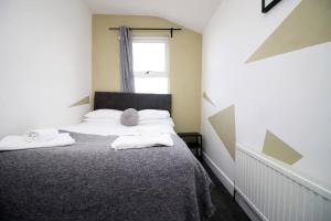 a bedroom with a bed with two towels on it at K Suites - Lansdown Road 2 in Bristol