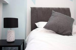 - un lit avec un oreiller et une lampe sur une table dans l'établissement K Suites - Lansdown Road 2, à Bristol