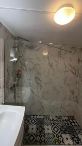 a bathroom with a shower and a tub and a sink at Hôtel Marie Louise in Enghien-les-Bains