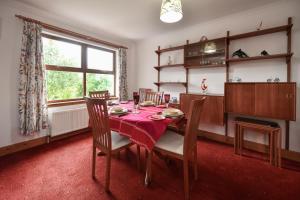 a dining room with a table and chairs and a window at North Blairkip Eildon in Sorn