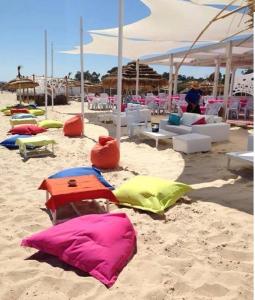 a sandy beach with chairs and tables and umbrellas at Regency Hammamet in Hammamet Sud
