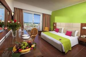 a bedroom with a bed and a table with a bowl of fruit at Regency Hammamet in Hammamet Sud