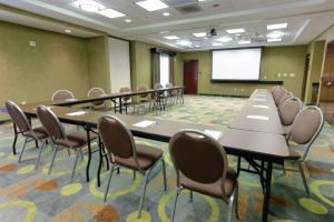 a conference room with tables and chairs and a screen at Hampton Inn & Suites Flowery Branch in Flowery Branch