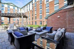 eine Terrasse mit Stühlen, Tischen und einer Feuerstelle in der Unterkunft Homewood Suites by Hilton Hartford South-Glastonbury in Glastonbury