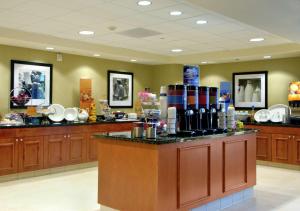 a restaurant with a counter with dishes on it at Hampton Inn & Suites Seal Beach in Seal Beach