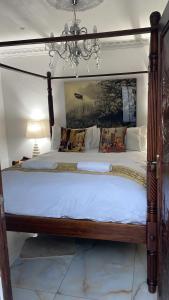 un grande letto con struttura in legno in una camera da letto di Casa 57 a Pietermaritzburg