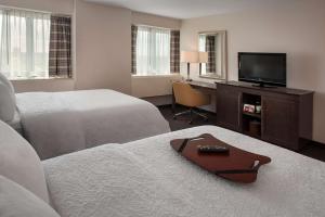 a hotel room with two beds and a flat screen tv at Hampton Inn & Suites Milwaukee Downtown in Milwaukee
