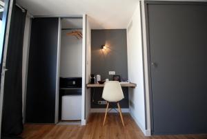 a room with a desk and a white chair at Les Jardins De Galicia in Sète