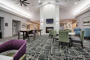 Homewood Suites by Hilton Leesburg في ليسبورغ: لوبي مع طاولة وكراسي ومدفأة