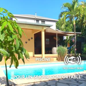 a house with a swimming pool in front of it at La Kaz Pomme Cannelle in Rivière