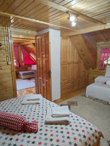 ein Schlafzimmer mit einem Bett in einer Holzhütte in der Unterkunft Vila Maja in Rudno